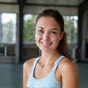 Portrait of Coach Elena Rodriguez, with a warm and encouraging smile.